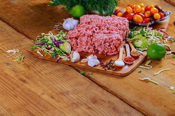 Minced beef raw on wood table with herbs and spice