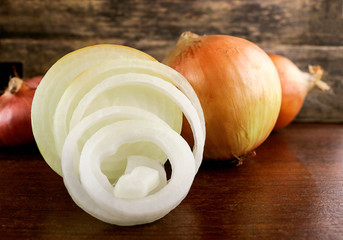 fresh onion and onion rings on wooden background.
