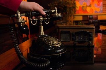 an old telephone with rotary dial; antique telephone receiver in hand held