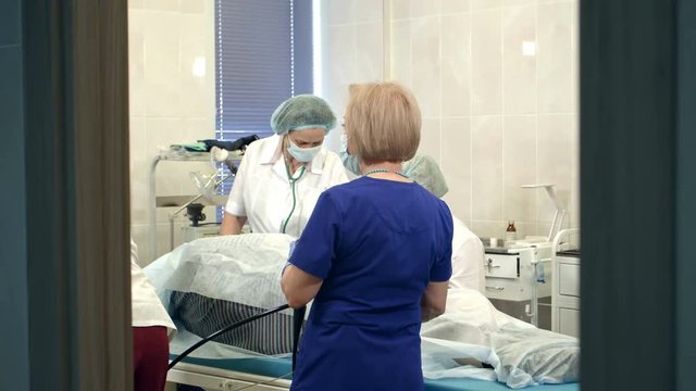 Doctors managing modern endoscope during medical procedure at hospital