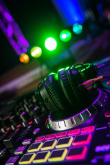 Naklejka na ściany i meble Dj mixer with headphones at a nightclub