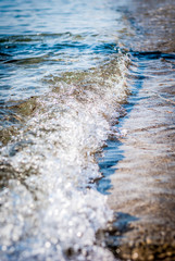 The blue sea, the coast and the beautiful sunny day. Small waves lapping at the shore