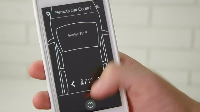Man remotely changes temperature in his car Car remote control using smartphone application fictional interface.