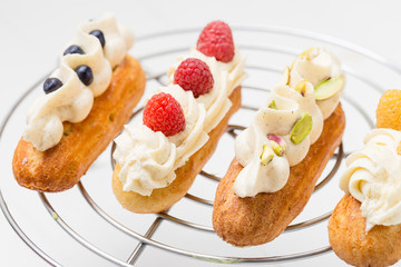 Eclairs with vanilla cream on white background