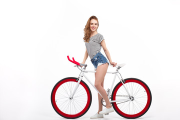 Fototapeta na wymiar Cheerful girl on bicycle in studio