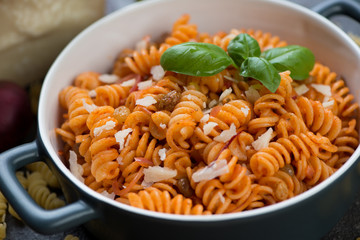 Fusilli pasta with red onion sauce and parmesan cheese, closeup, selective focus