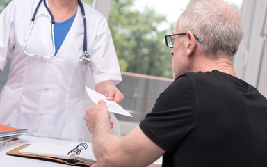 Female doctor giving prescription to her patient