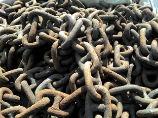 A detailed close up of rusted links in a large chain fence