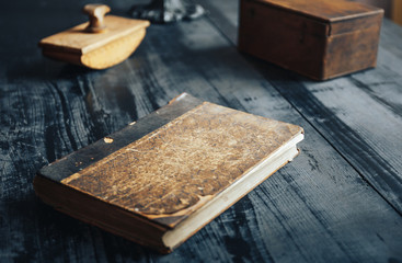 Old antique book and other objects on black wooden table