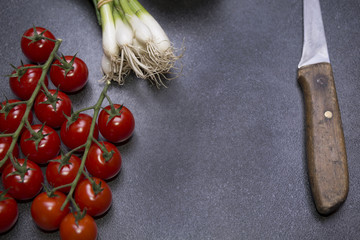 Tomato and young onions on the table with knife