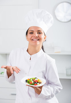 Brunette girl chef  and plate with salad