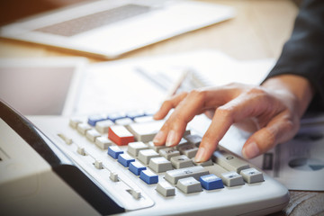 Business woman putting her hand on calculator, business and investment concept