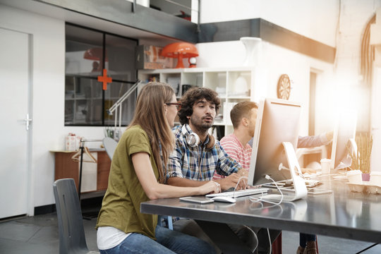 Start-up people working on desktop in co-working space