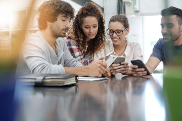 Group of young people playing with smartphones