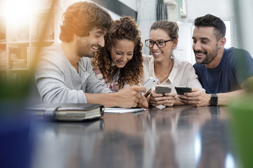 Group of young people playing with smartphones