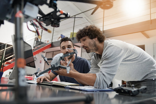 Engineer and technician working together on drone in office