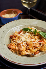 Pasta with seafood and cheese. Glass of white wine. Rustic style.