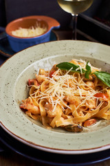 Pasta with seafood and cheese. Glass of white wine. Rustic style.