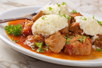 Classic goulash with dumplings on plate