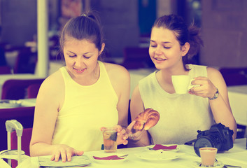 portrait of two female friends searching route on the map