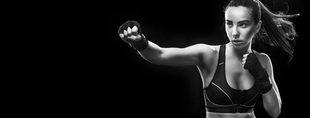 Female boxer fighting. Isolated on black background. Copy Space.
