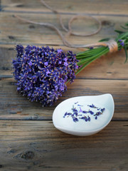 Bunch of lavander flowers and homemade cream from lavander on wooden table. Close up.