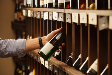 Expert in winemaking choose elite white wine in cellar.