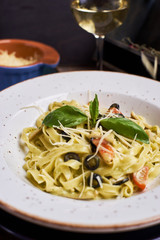 Traditional italian cuisine. Pasta with cjicken slices and mozarella cheese. Glass of wine.