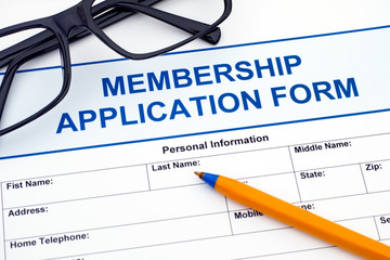 Membership application form with pen and glasses