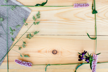 Small field flowers on wooden background. Floral background.
