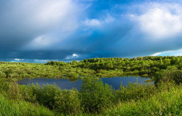 Fototapeta na wymiar Landscape with a small lake and stormy skies.