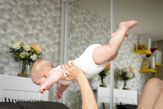 A child on the arms of Mom in flight when playing in the bedroom