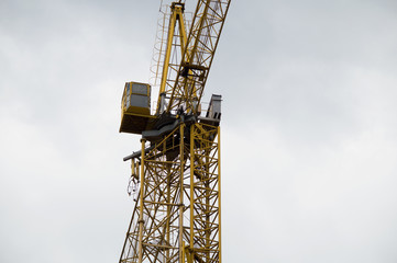 Tower crane cabin against the sky. The cockpit of a construction crane