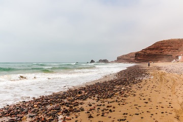 Coast, waves and beach with yellow sand and pebbles