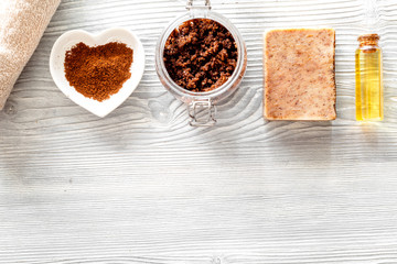 Homemade skin care. Coffee soap, coffee scrub, coffee grains, oil on wooden background top view copyspace