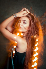 Naklejka premium Fashionable model with hair in motion in mixed light at studio
