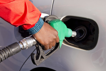 Male hand holding a green petrol pump