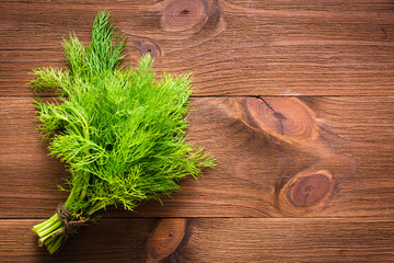 Bunch of fresh dill on wooden background. Top view