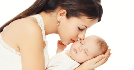 Portrait of young loving mother kissing her baby on a white background