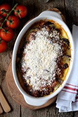 Baked Eggplants with mozzarella, parmesan cheese, tomato sauce and breadcrumbs on an old wooden background. Rustic style.