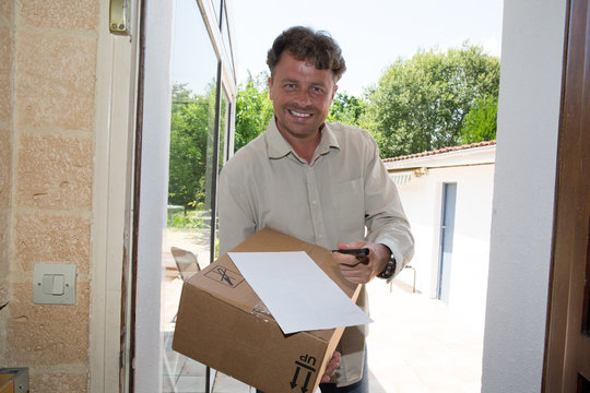 Smiling delivery man holding a paper box