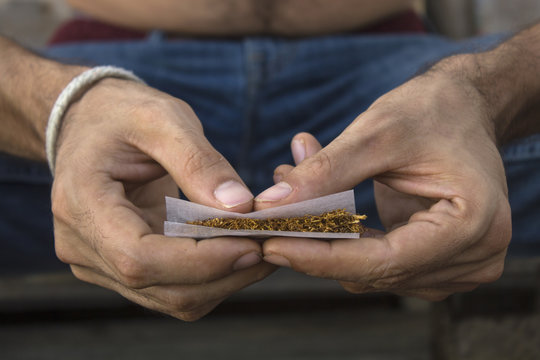Man's hands rolling a joint
