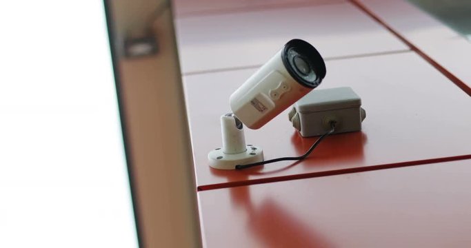 Security IR camera for monitor events in city on red wall modern building technology concept 4k