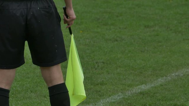 Linesman referee with flag in the hand observing the match.