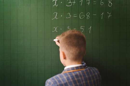 Child Writing On Green Chalkboard With Withe Chalk