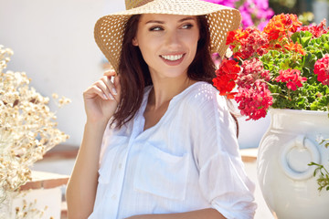 Young pretty woman smiling. Beautiful women in a straw hat at the summer garden.