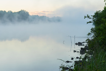 Quiet calm early morning on lake in summer. Magic dawn with fog. Concept of seasons,ecology, environment, natural background