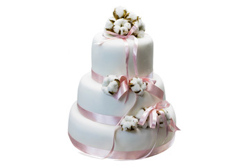 White three-tiered cake with cotton and pink ribbon isolated on white background