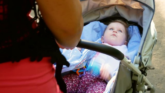 Mother walks with her daughter in a baby carriage