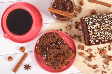 Cake with chocolate, cocoa and plum jam, cup of coffee